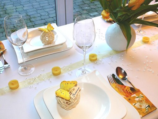 Tischdeko-online mit einem Gelben Mustertisch 2. Gelbe Tulpen, Tischbändern, und Rattanherzen. Tischdekoration zur Hochzeit und Tipps.